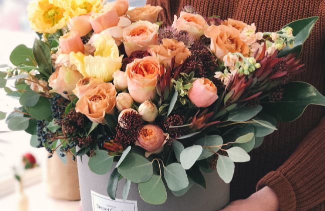  A photo of a woman holding a box of flowers