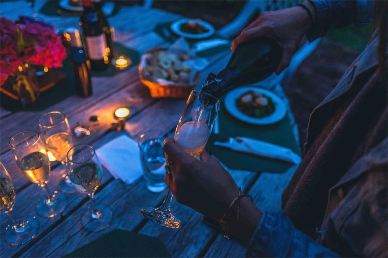 A person pouring wine into a wine glass