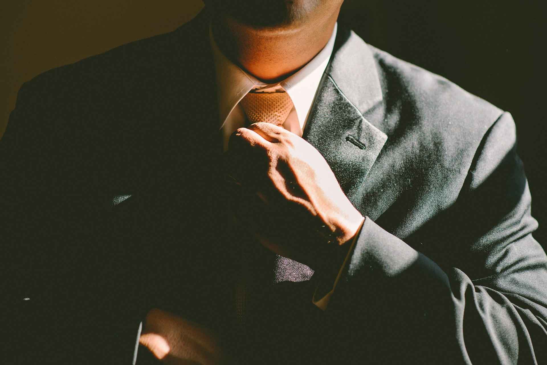 A man trying to straighten his tie.