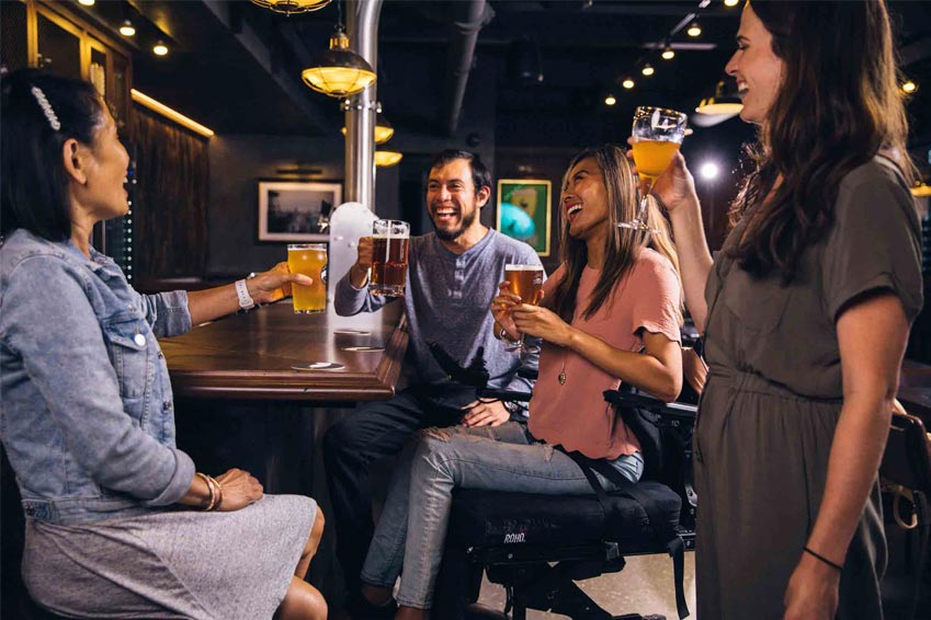 A man drinking beer at the bar with 3 beautiful Ukrainian women.