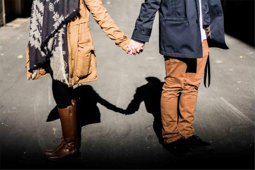 man and woman standing while holding hands