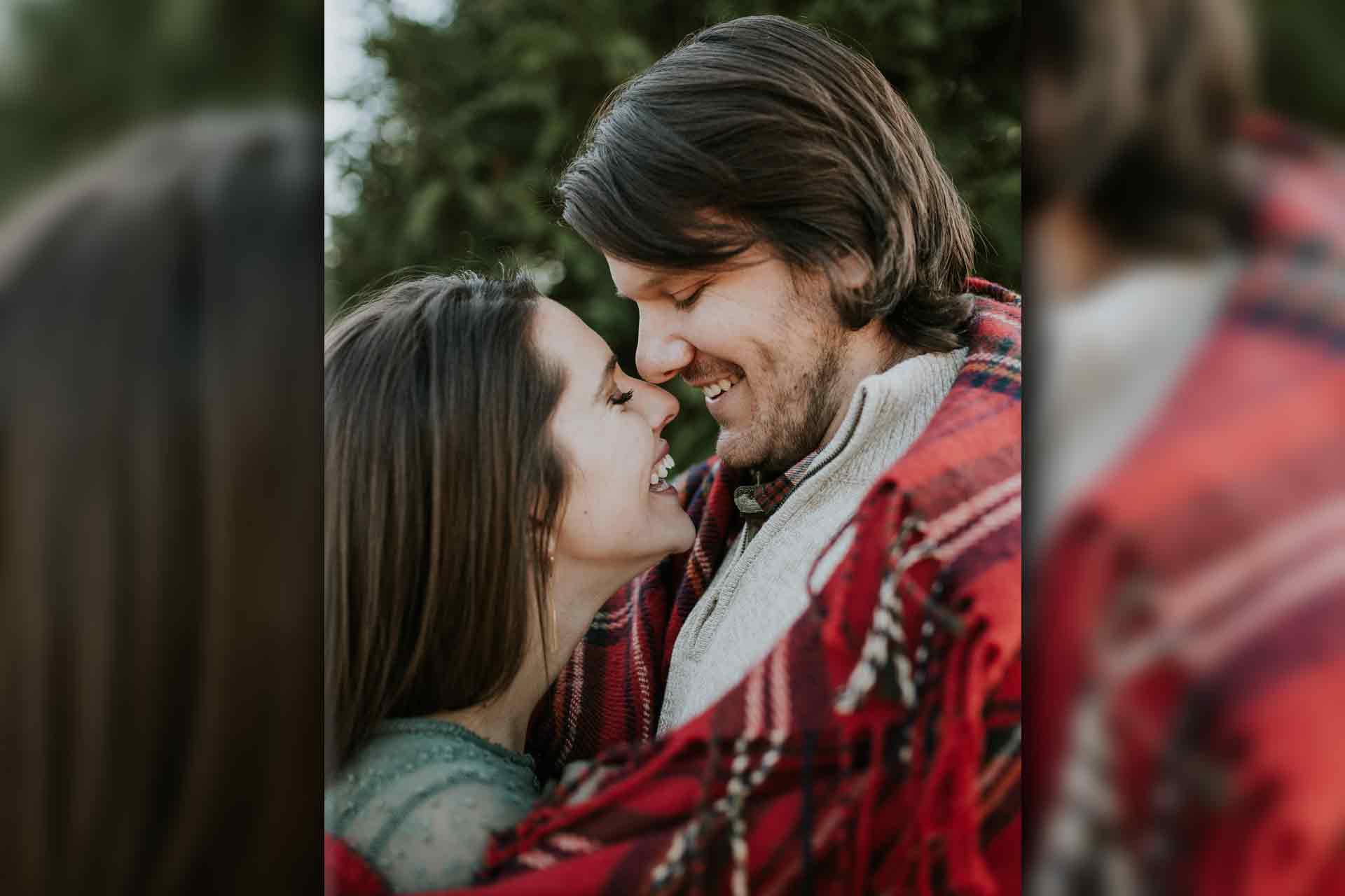 man and woman wrapped in red blanket